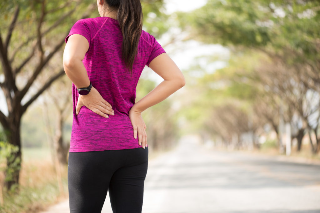 young woman exercising feel sudden pain in lower back
