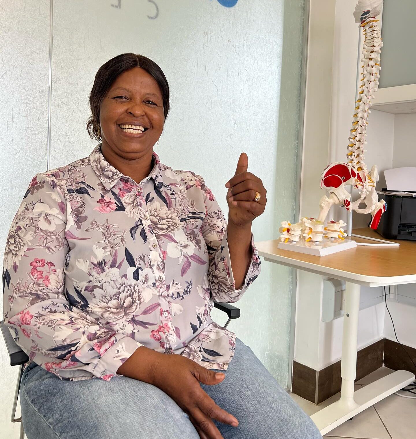 Patient smiling and giving thumbs up during a chiropractic visit